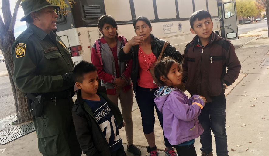 In this Thursday, Nov. 29, 2018 photo, a migrant family from Central America waits outside the Annunciation House shelter in El Paso, Texas, after a U.S. Immigration and Customs Enforcement officer drops them off. Volunteer shelters along the U.S.-Mexico border say they are preparing for an expected surged of new immigrants seeking asylum in the U.S. who will need temporary housing as the holidays approach. (AP Photo/Russell Contreras) **FILE**