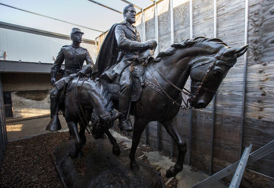 FILE - In this Dec. 20, 2018, file photo the 1935 statue of Robert E. Lee, right, and a young soldier by sculptor Alexander Phimister, sit in storage at Hensley Field, the former Naval Air Station on the west side of Mountain Creek Lake in Dallas. Dallas City Council on Wednesday, May 22, 2019 declared the statue surplus property and offered to sell it for a minimum $450,000, what it cost to move the bronze artwork from public view. The statue was removed from a park in September 2017 and put in storage and has been appraised at $950,000, which Dallas authorities say could pay for removal of the city's Confederate War Memorial. (Ashley Landis/The Dallas Morning News via AP, File)/The Dallas Morning News via AP)