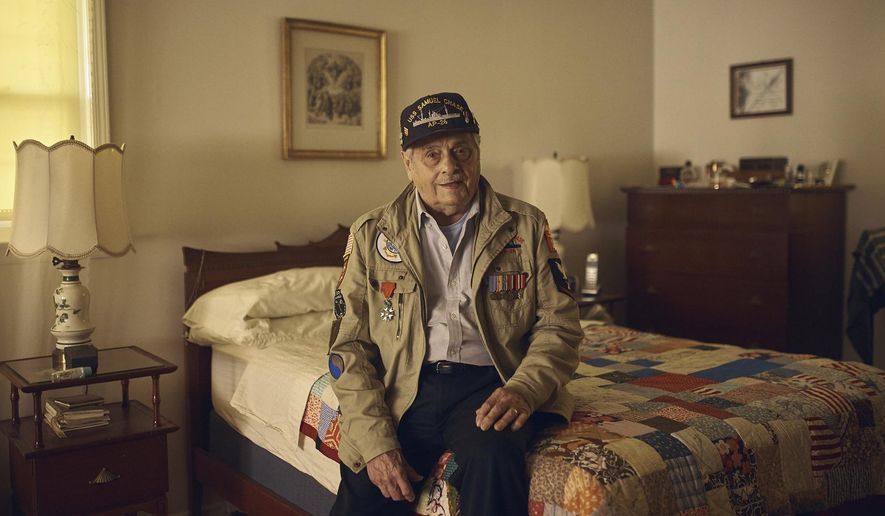 In this May 14, 2019, photo, World War II U.S. veteran Frank DeVita, who took part in the D-Day battle, poses for a picture at his home in Bridgewater, N.J. This June he’ll make his 12th trip back to Normandy. He likes to bring people with him so they’ll know what happened there. (AP Photo/Andres Kudacki)