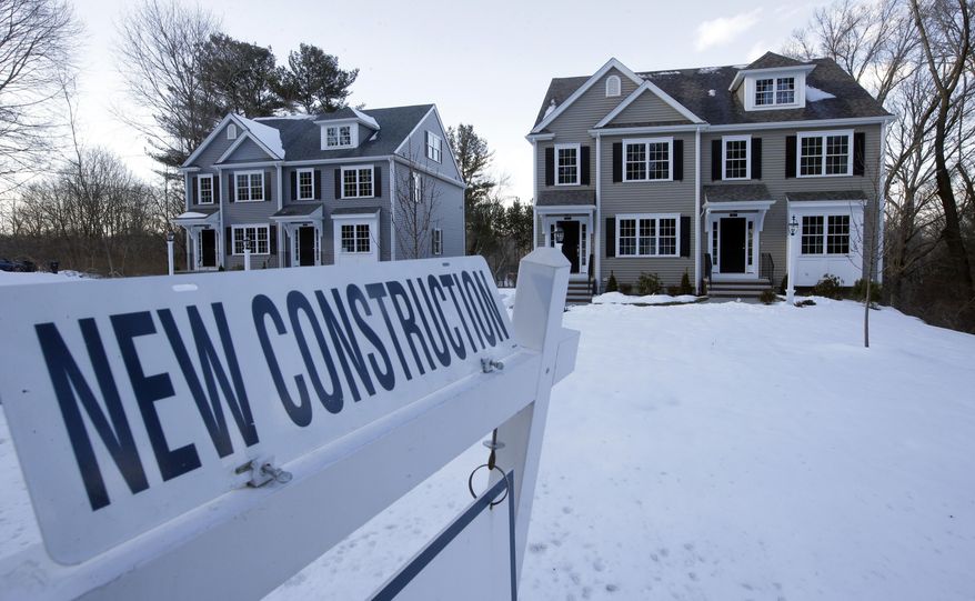 FILE- In this Feb. 21, 2019, file photo a newly constructed homes sit near a sign in Natick, Mass. On Thursday, May 23, the Commerce Department reports on sales of new homes in April. (AP Photo/Steven Senne, File)