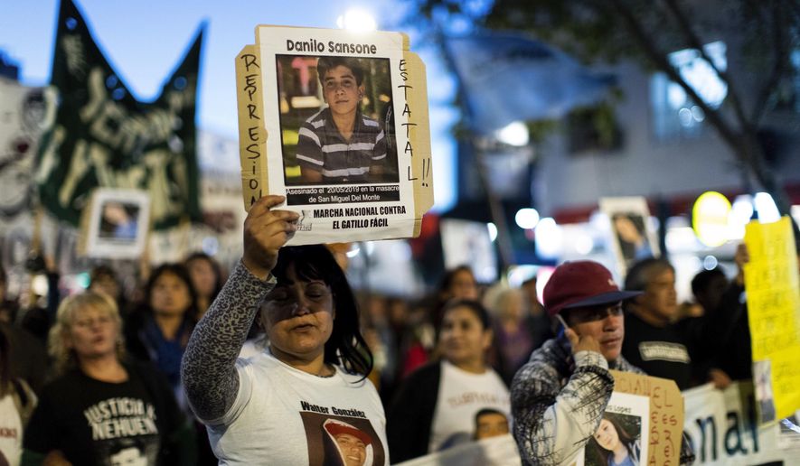 Demonstrators hold posters of the four victims of Monday's police shooting, during a march against police brutality, in Buenos Aires, Argentina, Friday, May. 24, 2019. Argentines protested after officers on Monday fired shots that led to the deaths of three teenagers and a young man in a car chase. (AP Photo/Tomas F. Cuesta)