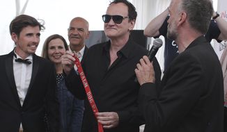 Director Quentin Tarantino poses for photographers with the Palm Dog collar award for the the dog Brandy that appeared in his film &#39;Once Upon a Time in Hollywood&#39; at the 72nd international film festival, Cannes, southern France, Friday, May 24, 2019. (AP Photo/Petros Giannakouris)