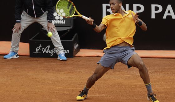 FILE - In this Monday, May, 13, 2019 filer, Canada&#39;s Felix Auger-Aliassime returns the ball to Croatia&#39;s Borna Coric during their match at the Italian Open tennis tournament, in Rome. It’s typically Canadian that Denis Shapovalov, Felix Auger-Aliassime and Bianca Andreescu are each children of immigrants. What’s not typical is that they have all simultaneously broken into the world’s elite ranks of tennis players _ and will all be worth watching when the French Open begins Sunday. (AP Photo/Gregorio Borgia, File)
