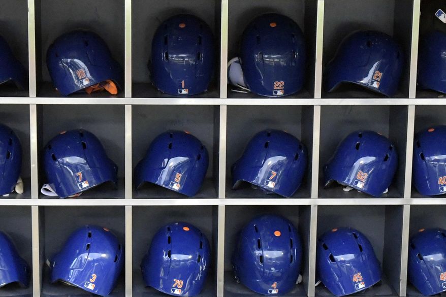 This Sept. 28, 2018 photo shows batting helmets in a rack before a Major League Baseball game in New York. According to study published Friday, May 24, 2019, NFL players may be more likely to die from brain diseases and heart problems than MLB players but the reasons are unclear. (AP Photo/Bill Kostroun)