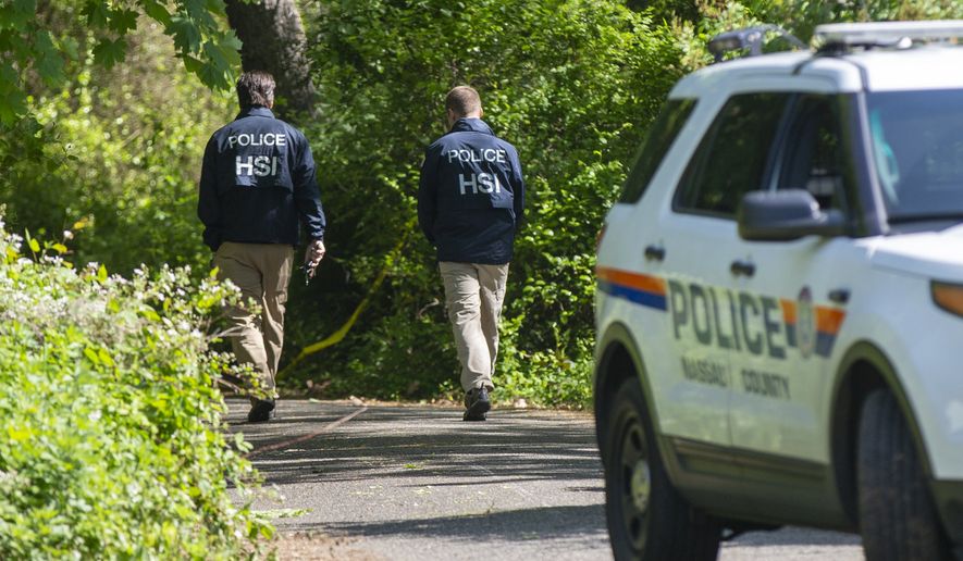 Nassau Police with federal partners conduct an investigation at the Massapequa preserve on Saturday, May 25, 2019 at the Massapequa Preserve in Massapequa, N.Y. after a body was found in a shallow grave the day before. The body has not been identified, but police say the victim is one of 11 people killed by MS-13 gang members in 2016. (Howard Schnapp/Newsday via AP)
