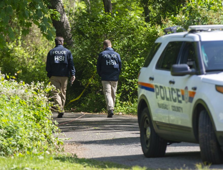 Nassau Police with federal partners conduct an investigation at the Massapequa preserve on Saturday, May 25, 2019 at the Massapequa Preserve in Massapequa, N.Y. after a body was found in a shallow grave the day before. The body has not been identified, but police say the victim is one of 11 people killed by MS-13 gang members in 2016. (Howard Schnapp/Newsday via AP)