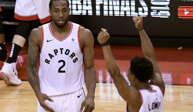 Toronto Raptors&#x27; Kawhi Leonard (2) and Kyle Lowry (7) react during the second half of Game 6 of the team&#x27;s NBA basketball playoffs Eastern Conference finals against the Milwaukee Bucks on Saturday, May 25, 2019, in Toronto. The Raptors won 100-94 to advance to the NBA Finals. (Frank Gunn/The Canadian Press via AP)