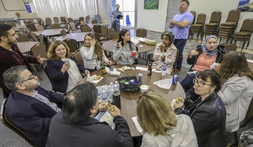 Volunteers from the International Institute of Metropolitan Detroit, Chaldean Community Foundation, South Asian American Voices of Impact, and Justice for Our Neighbors stop for lunch during the day-long Detroit New Americans campaign citizenship workshop at the Yemeni American Leadership Association in Hamtramck, Mich. on Friday, April 26, 2019. (Kimberly P. Mitchell/Detroit Free Press via AP)