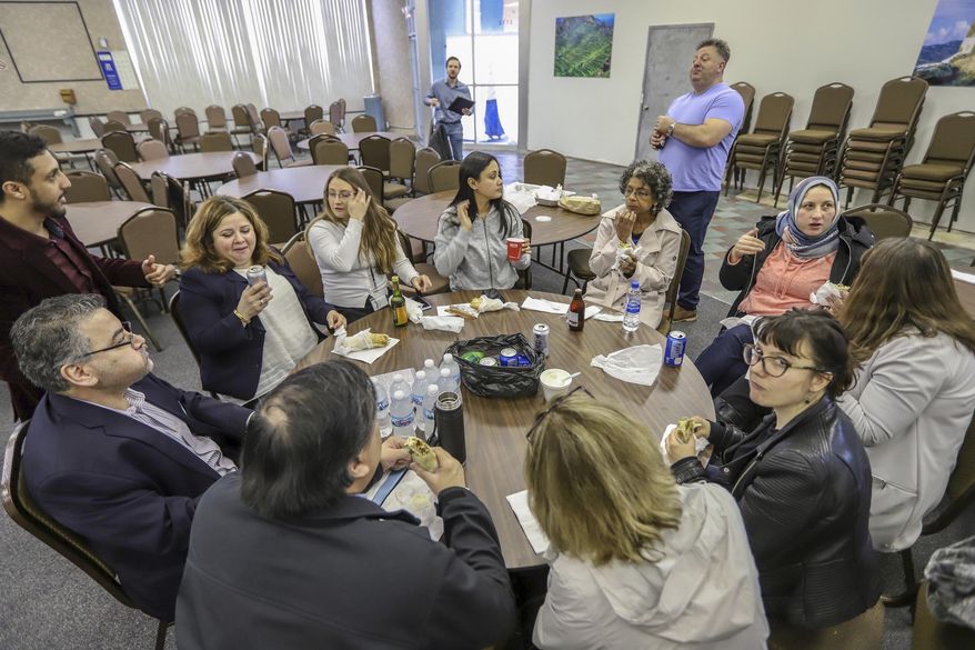Volunteers from the International Institute of Metropolitan Detroit, Chaldean Community Foundation, South Asian American Voices of Impact, and Justice for Our Neighbors stop for lunch during the day-long Detroit New Americans campaign citizenship workshop at the Yemeni American Leadership Association in Hamtramck, Mich. on Friday, April 26, 2019. (Kimberly P. Mitchell/Detroit Free Press via AP)