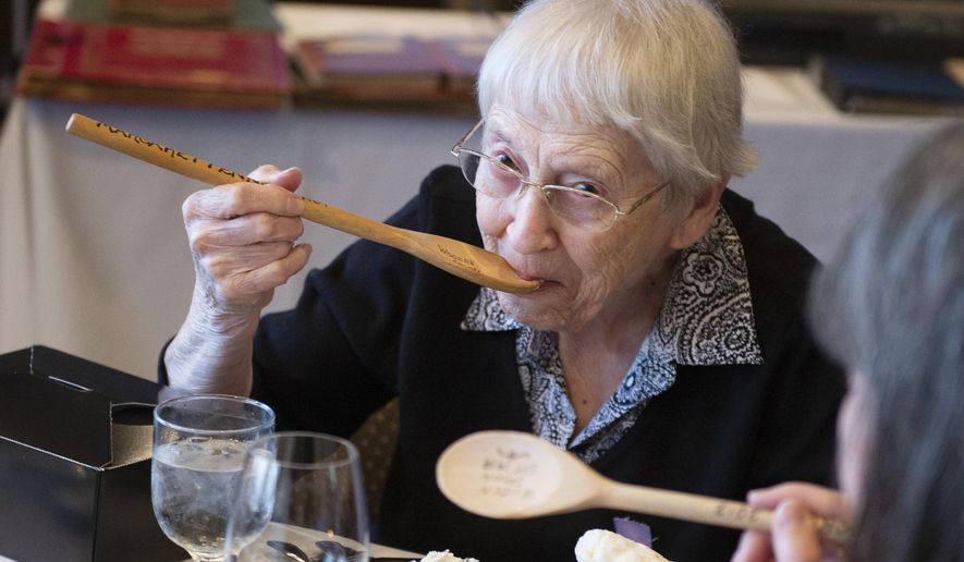 Margaret Penney, the person who has the longest membership of the Wooden Spoons, an all women's social club started by Louise Pound in 1919, takes a bite of ice cream with her wooden spoon during its final gathering on Tuesday, May 14, 2019, at US Bank. Penney became a member in 1969. It was tradition in the past to eat meals with the wooden spoons. Although the tradition stopped, Penney takes one bite using her spoon during the final gathering. (Emily Haney/Lincoln Journal Star via AP)