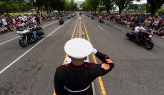 U.S. Marine Corps Staff Sgt. Tim Chambers salutes as motorcyclists ride in the 32nd Operation Rolling Thunder rally on Sunday in the District. The event honors prisoners of war and those killed in action. (Associated Press)
