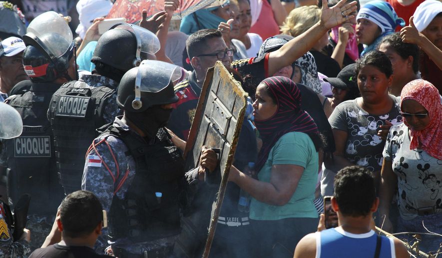 Relatives argue with police for more information outside the Anisio Jobim Prison Complex where a deadly riot erupted among inmates in Manaus in the northern state of Amazonas, Brazil, Sunday, May 26, 2019. A statement from the state prison secretary says prisoners began fighting among themselves around noon Sunday, and security reinforcements were rushed to complex. (AP Photo/Edmar Barros)