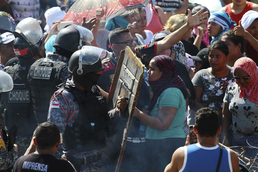 Relatives argue with police for more information outside the Anisio Jobim Prison Complex where a deadly riot erupted among inmates in Manaus in the northern state of Amazonas, Brazil, Sunday, May 26, 2019. A statement from the state prison secretary says prisoners began fighting among themselves around noon Sunday, and security reinforcements were rushed to complex. (AP Photo/Edmar Barros)