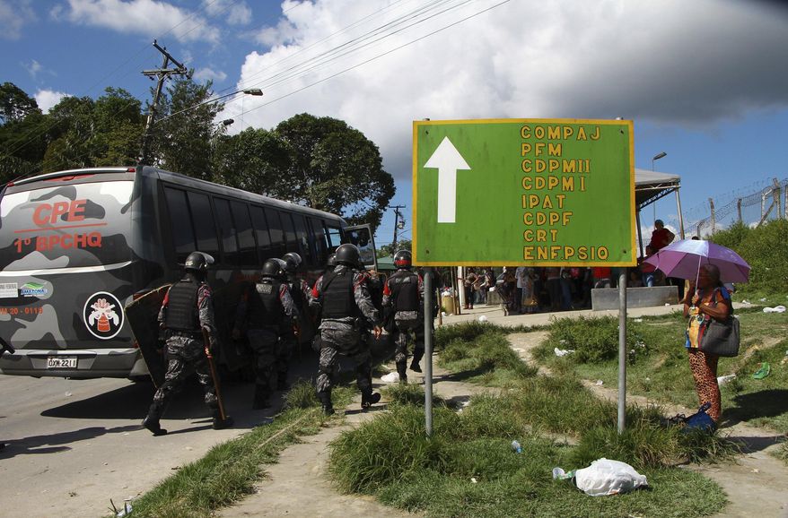 Police gather outside the Anisio Jobim Prison Complex after a deadly riot erupted among inmates in Manaus in the northern state of Amazonas, Brazil, Sunday, May 26, 2019. A statement from the state prison secretary says prisoners began fighting among themselves around noon Sunday, and security reinforcements were rushed to complex. (AP Photo/Edmar Barros)
