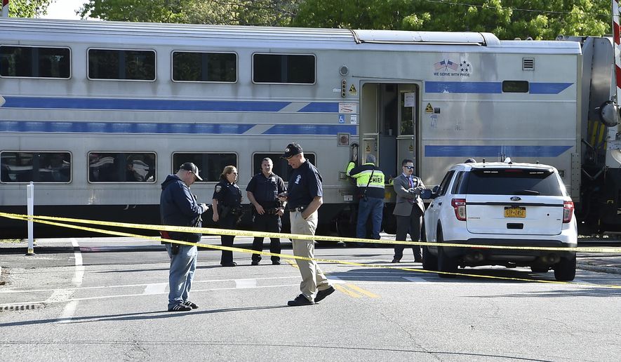Authorities gather at the scene of a Long Island Rail Road passenger train derailment in Southampton, N.Y., Saturday, May 25, 2019. The LIRR tweeted that the derailment followed a "slow-speed impact" between a passenger train and a work train at around 4 a.m. Saturday. No injuries were reported. Train service to the east end of Long Island is suspended for the first day of Memorial Day weekend after the early morning derailment. (John Roca/Newsday via AP)