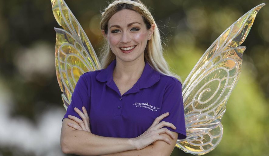 In this May 8, 2019 photo, Amy Sharpe poses with her angel wings in Lakeland, Fla. Sharpe started a business called Dreams Come True Entertainment in 2011. She provides princesses and superheroes for birthday parties and other kids&#x27; events. She also does charity events. (Pierre DuCharme/The Ledger via AP)