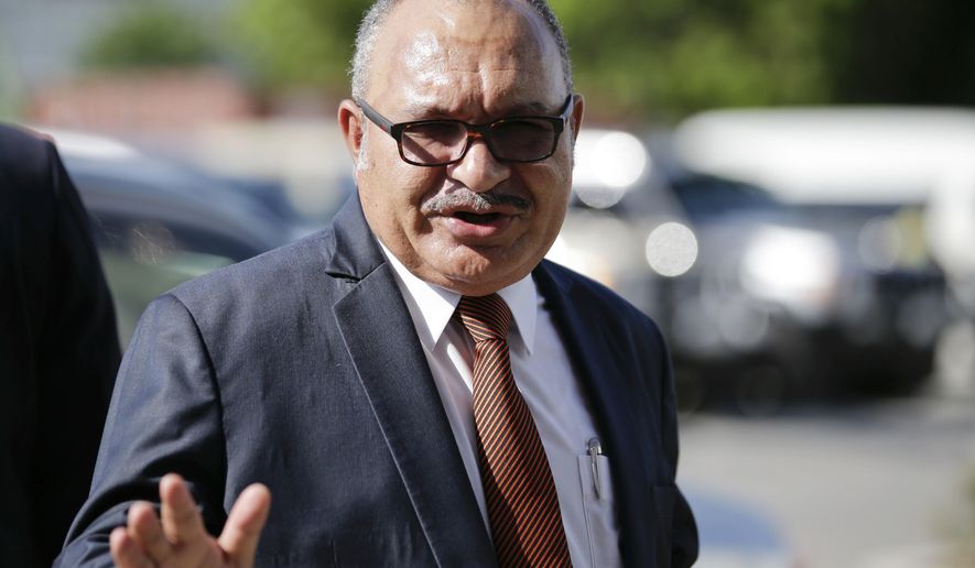 FILE - In this Nov. 14, 2018, file photo, Papua New Guinea Prime Minister Peter O'Neill gestures after inspecting the APEC 2018 International Media Center at Port Moresby, Papua New Guinea. O'Neill has resigned Sunday after seven years on the job. His announcement follows weeks of high profile defections from his government to the opposition. (AP Photo/Aaron Favila, File)
