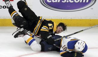 Boston Bruins&#x27; Torey Krug (47) and St. Louis Blues&#x27; Robert Thomas (18) crash to the ice during the third period in Game 1 of the NHL hockey Stanley Cup Final, Monday, May 27, 2019, in Boston. (AP Photo/Charles Krupa)