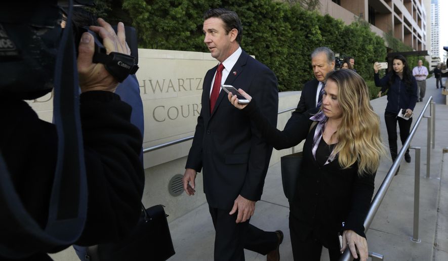 FILE - In this Dec. 3, 2018 file photo Republican Rep. Duncan Hunter, center, leaves court in San Diego. Hunter of has acknowledged taking a photo with a dead combatant during his time as a Marine as he defended a Navy SEAL charged with multiple war crimes. The Republican congressman made the comments during a town hall in his San Diego-area district. (AP Photo/Gregory Bull, File)