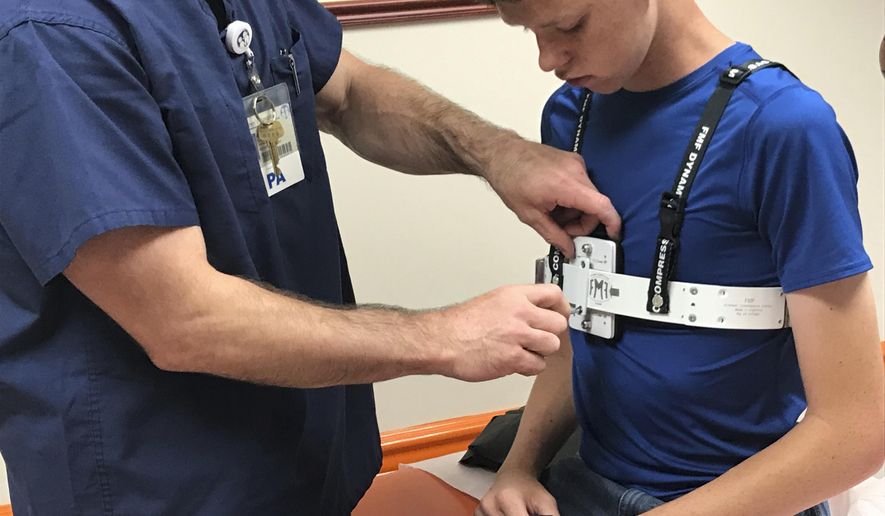 Physician's assistant Matt Greiner uses a screwdriver to tighten a plate to put the correct amount of pressure on 14-year-old Tinsley Allen's chest May 17, 2019 at East Tennessee Children's Hospital in Knoxville, Tenn,. Tinsley is a patient at the hospital, which recently began a clinic specifically for children with chest wall abnormalities. (Kristi L. Nelson/Knoxville News Sentinel via AP)