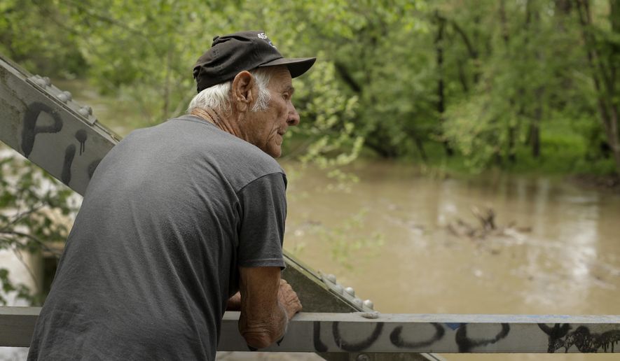 In this photo taken May 8, 2019, Elmer Sullivan checks out high water in the Fishing River in the small community of Mosby, Mo. Sullivan and nearly half of the homeowners in Mosby signed up in 2016 for a program in which the government would buy and then demolish their properties rather than paying to rebuild them over and over. They're still waiting for offers, joining thousands of others across the country in a slow-moving line to escape from flood-prone homes. (AP Photo/Charlie Riedel)
