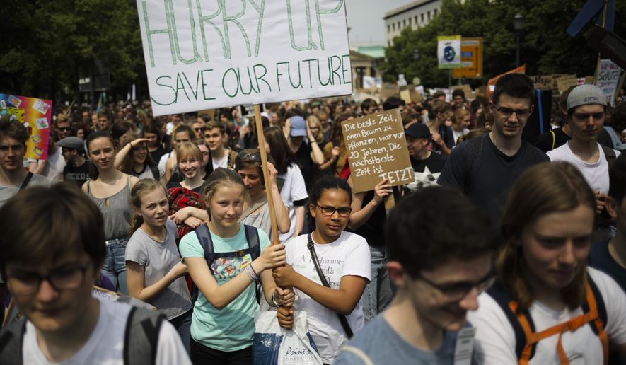 Students hold posters as they attend a protest rally of the "Friday For Future" movement in Berlin, Germany, Friday, May 24, 2019. The German language poster reads: "The best time to plant a tree was 20 years ago. The next best time is now." (AP Photo/Markus Schreiber) ** FILE **