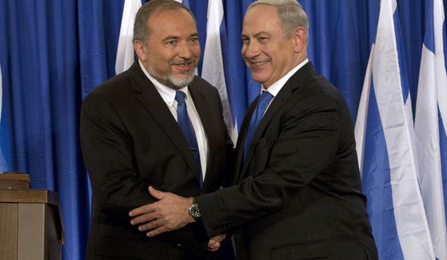 FILE - In this Oct. 25, 2012 file photo, Israeli Prime Minister Benjamin Netanyahu, right, and former Israeli Defense Minister Avigdor Lieberman shake hands in front of the media after giving a statement in Jerusalem. Netanyahu is facing the possibility of having to fight a second election this year, as he struggles to form a coalition government. With a looming deadline, Israel&#x27;s newly elected parliament began drafting a bill on Monday to dissolve itself. (AP Photo/Bernat Armangue, File)