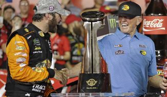 Martin Truex Jr., left, is congratulated by team owner Joe Gibbs in Victory Lane after winning the NASCAR Cup Series auto race at Charlotte Motor Speedway in Concord, N.C., Sunday, May 26, 2019. (AP Photo/Chuck Burton)