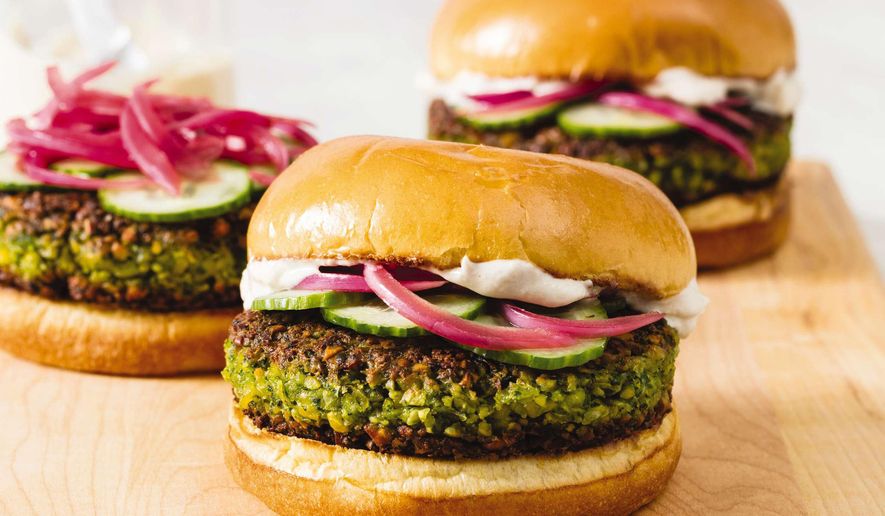 This undated photo provided by America's Test Kitchen in May 2019 shows Falafel Burgers with Tahini-Yogurt Sauce in Brookline, Mass. This recipe appears in the cookbook “The Ultimate Burger.” (Daniel J. van Ackere/America's Test Kitchen via AP)