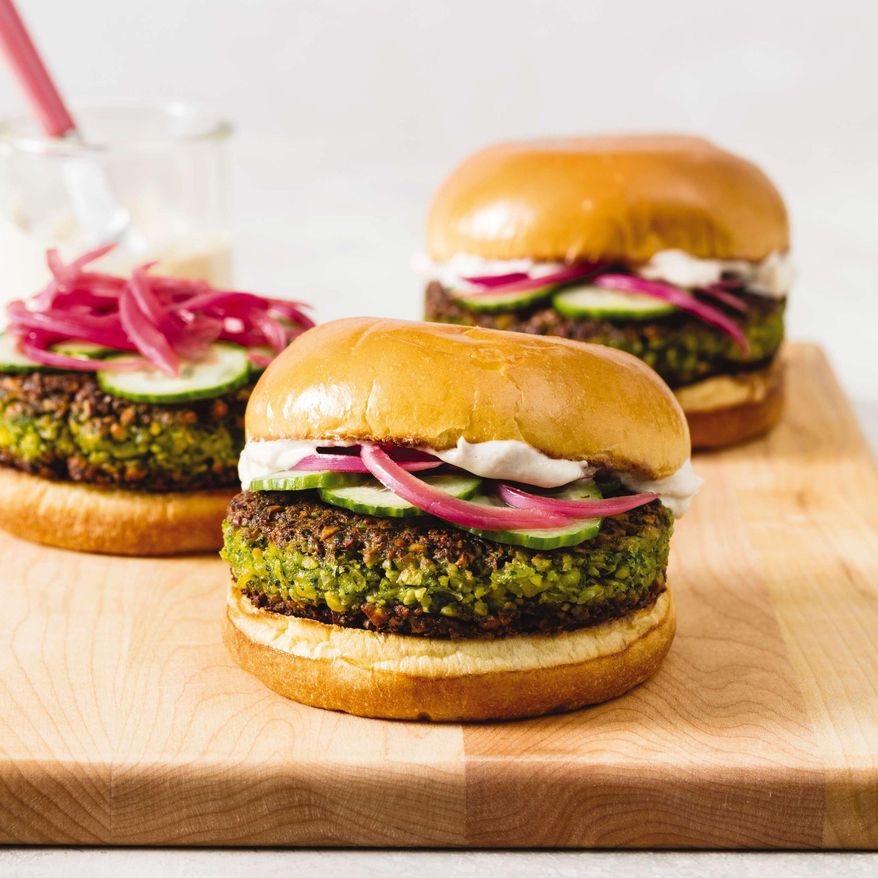 This undated photo provided by America's Test Kitchen in May 2019 shows Falafel Burgers with Tahini-Yogurt Sauce in Brookline, Mass. This recipe appears in the cookbook “The Ultimate Burger.” (Daniel J. van Ackere/America's Test Kitchen via AP)