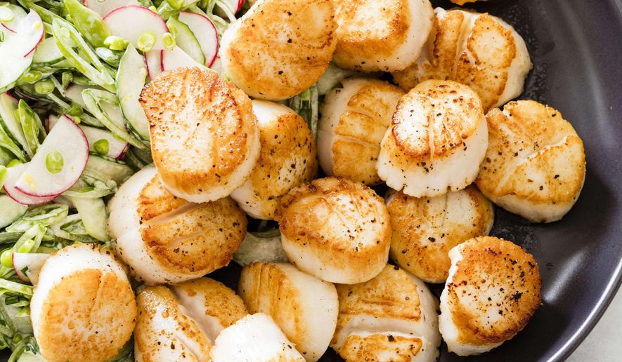 This undated photo provided by America's Test Kitchen in May 2019 shows Pan-Seared Scallops with Slaw in Brookline, Mass. This recipe appears in the cookbook “Vegetables Illustrated.” (Daniel J. van Ackere/America's Test Kitchen via AP)