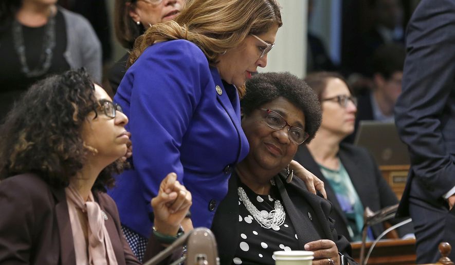 Assemblywoman Shirley Weber, D-San Diego, seated right, is congratulated by Assemblywoman Sharon Quirk-Silva, D-Fullerton, standing left, after her police use of force measure was approved by the Assembly, Wednesday, May 29, 2019, in Sacramento, Calif. By a bipartisan vote the Assembly approved her bill, AB392, that would bar police using lethal force unless it is necessary to prevent immediate harm to themselves or others. (AP Photo/Rich Pedroncelli)