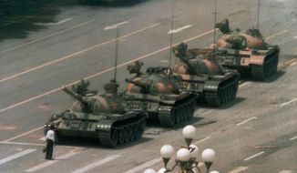 FILE - In this June 5, 1989 file photo, a Chinese man stands alone to block a line of tanks heading east on Beijing&#39;s Changan Blvd. in Tiananmen Square. The man, calling for an end to the recent violence and bloodshed against pro-democracy demonstrators, was pulled away by bystanders, and the tanks continued on their way. Over seven weeks in 1989, student-led pro-democracy protests centered on Beijing’s Tiananmen Square became China’s greatest political upheaval since the end of the Cultural Revolution more than a decade earlier.(AP Photo/Jeff Widener, File )