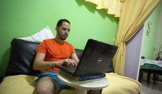 FILE - In this Jan. 6, 2017 photo Roberto Carlos Villamar uses his laptop on the new experimental internet in the living room of his home in Havana, Cuba. Cuba announced Wednesday, May 29, 2019 that it is legalizing private Wi-Fi networks and the importation of equipment like routers, eliminating one of the world&#39;s tightest restrictions on internet use. (AP Photo/Desmond Boylan, File)