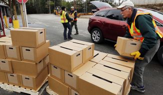 FILE - In this Monday, April 11, 2016 file photo, New Hampshire state and local officials load boxes of free bottled water in in Litchfield, N.H. New Hampshire is suing eight companies including 3M and Dupont for damage it says has been caused statewide by a class of potentially toxic chemicals found in everything from pizza boxes to fast-food wrappers. The state becomes the second in the nation to go after the makers of perfluoroalkyl and polyfluoroalkyl substances or PFAS and the first to target statewide contamination. (AP Photo/Jim Cole, File)