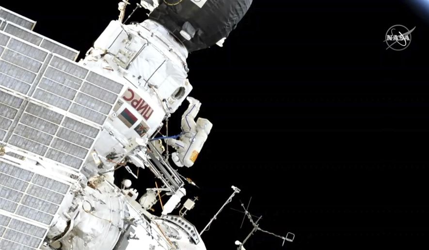 In this image made from video provided by NASA, Expedition 59 Commander Oleg Kononenko, center, participates in a spacewalk outside the International Space Station with Flight Engineer Alexey Ovchinin, obscured, on Wednesday, May 29, 2019. (NASA via AP)