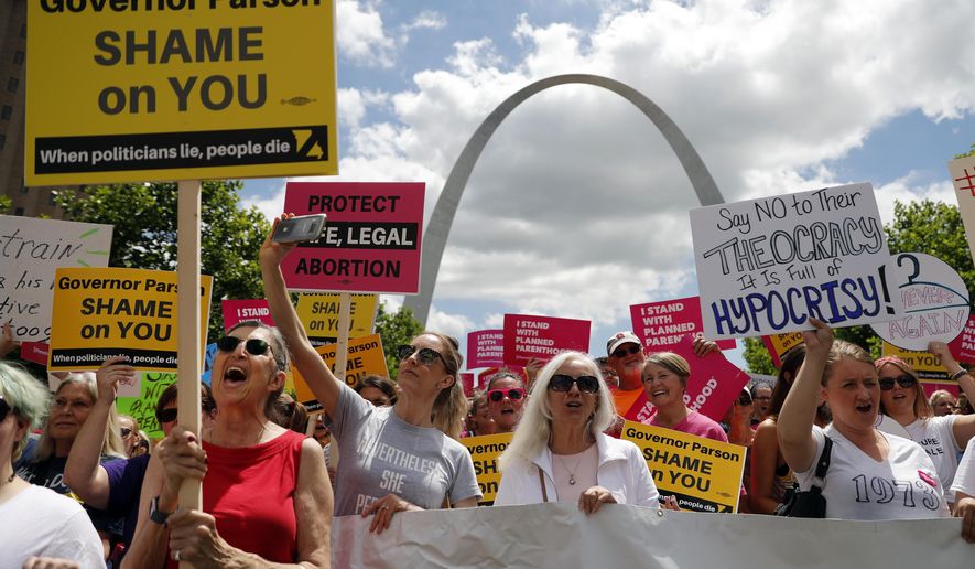 Abortion-rights supporters take part in a protest Thursday, May 30, 2019, in St. Louis. A St. Louis judge heard an hour of arguments Thursday on Planned Parenthood's request for a temporary restraining order that would prohibit the state from allowing the license for Missouri's only abortion clinic to lapse at midnight Friday. (AP Photo/Jeff Roberson)