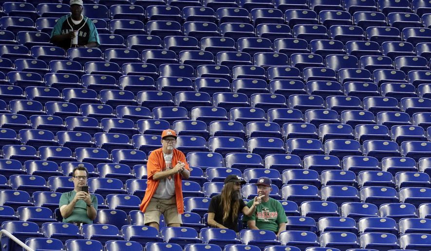 Fans watch a baseball game between the Miami Marlins and San Francisco Giants, Thursday, May 30, 2019, in Miami. Major League Baseball's average attendance of 26,854 is 1.4% below the 27,242 through the similar point last season, which wound below 30,000 for the first time since 2003. Baltimore, Cincinnati, Minnesota and Tampa Bay set stadium lows this year. Kansas City had its smallest home crowd since 2011, and Toronto and San Francisco since 2010. Miami and the Rays drew 12,653 Wednesday night _ combined. (AP Photo/Lynne Sladky)
