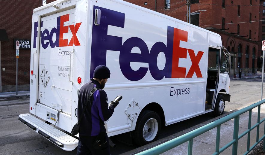 FILE - In this March 17, 2017, photo, a FedEx driver returns to his truck in downtown Pittsburgh.  FedEx plans to deliver packages seven days a week starting next January 2020 as it tries to keep up with the continuing boom in online shopping.  The Memphis, Tennessee-based company announced the moves Thursday, May 30, 2019.  (AP Photo/Gene J. Puskar, File)