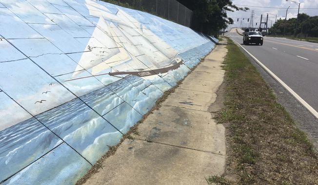 Traffic passes a mural along Africatown Boulevard in Mobile, Alabama, on Thursday, May 30, 2019. An archaeological report will be released Thursday, May 30, 2019 on the discovery of what experts believe is the last ship known to have brought enslaved people from Africa to the United States. The event in the Africatown community of Mobile also will include a community celebration and commemoration event marking the discovery of the schooner Clotilda , according to the Alabama Historical Commission. (AP photo/Kevin McGill)