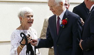 FILE - In this Aug. 9, 2018 file photo, former U.S. Sen. Thad Cochran, right, and his wife Kay Webber, react to a ripped rope attached to the veil over Cochran&#39;s name during the unveiling prior to the naming ceremony of the Thad Cochran United States Courthouse in downtown Jackson, Miss. Seven-term Republican Sen. Thad Cochran, who used seniority to steer billions of dollars to his home state of Mississippi, died Thursday, May 30, 2019. He was 81.  (AP Photo/Rogelio V. Solis, File)