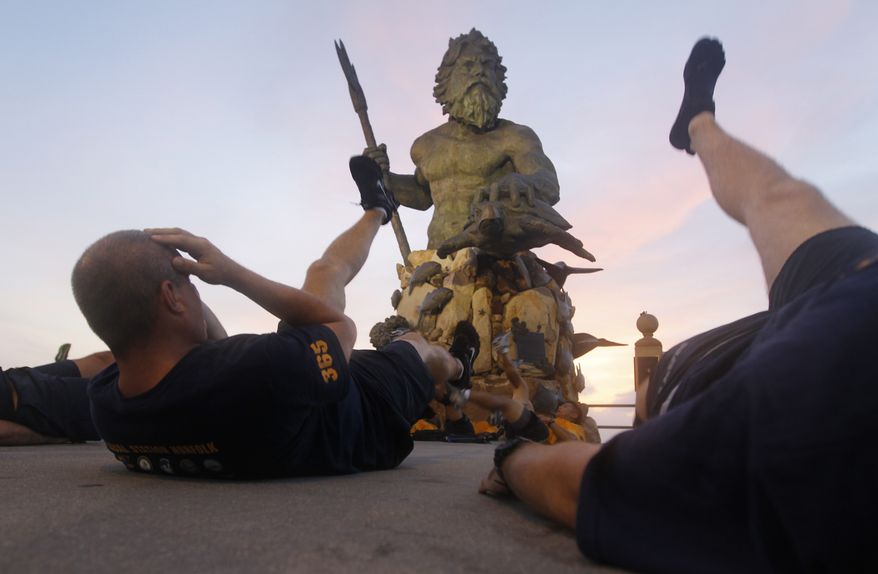 U.S. Navy Chief Petty Officers conduct physical training in front of a statue of Neptune on the oceanfront of Virginia Beach, Va., Friday, Aug. 26, 2011. (AP Photo/Steve Helber) **FILE**