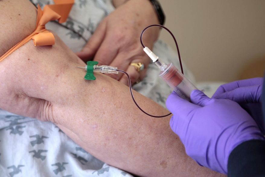 FILE - In this Tuesday, April 28, 2015 file photo, a patient has her blood drawn at a hospital in Philadelphia to monitor her cancer treatment. Companies are trying to develop blood tests that can look for signs of many types of cancer at once. (AP Photo/Jacqueline Larma, File)