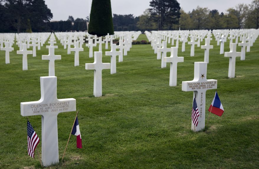 In this Wednesday, May 1, 2019 photo, the headstones of World War II U.S. Brigadier General Theodore Roosevelt Jr, right, and his brother World War I First Lieutenant Quentin Roosevelt, buried side by side at the Normandy American Cemetery in Colleville-sur-Mer, France. President Trump and his French counterpart Emmanuel Macron will next week honor the dwindling number of veterans of the D-Day landing that turned World War II amid plenty of signs the bonds of friendship are under strain. The United States has had a special bond with France throughout its history and especially during two world wars over the past century when even future presidents and sons of presidents risked their lives for the freedom of a friendly nation. (AP Photo/Virginia Mayo)