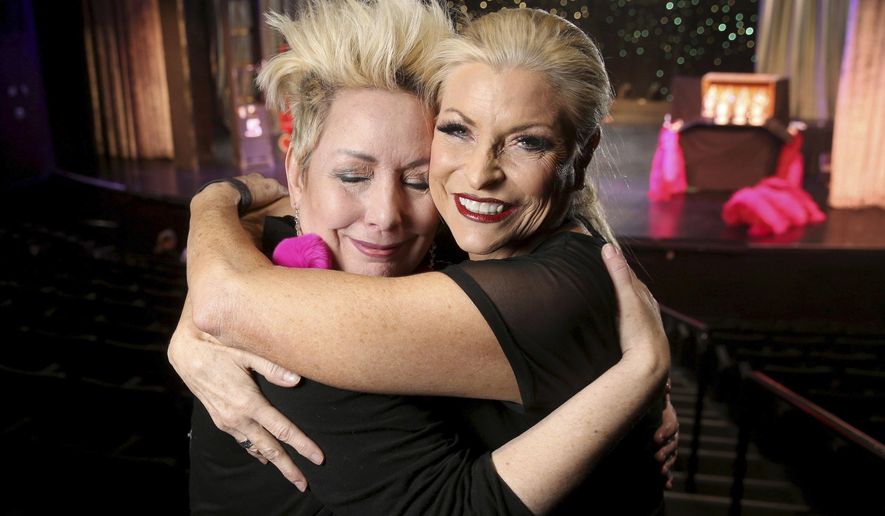 ADVANCE RELEASE FOR USE SATURDAY, JUNE 1, 2019, 12:01 a.m. AND THEREAFTER In this Thursday, May 23, 2019 photo, co-creators Mistinguett, left, and Stacy Law-Blind hug during a preview of "Showgirl Bootcamp" at Saxe Theater in Miracle Mile Shops at Planet Hollywood Resort in Las Vegas. The duo have put their 60-plus years of combined experience into “Showgirl Bootcamp,” a new, twice-daily workshop that’s as close as you can get to feeling like a part of Old Vegas. (K.M. Cannon/Las Vegas Review-Journal via AP)