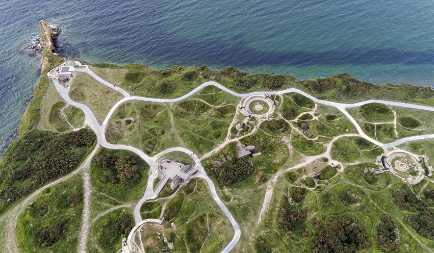 This photo taken on Thursday May 30, 2019 with a drone shows Pointe du Hoc, near Colleville-sur-Mer, Normandy. At the Pointe du Hoc, where Allied forces had to scale cliffs to silence Nazis guns, the limestone and clay cliffs have eroded but remains of the fortified location part of Germany's Atlantic Wall defensive system are a powerful vestige of WWII. (AP Photo/David Vincent)