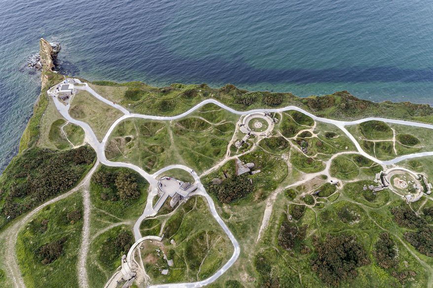This photo taken on Thursday May 30, 2019 with a drone shows Pointe du Hoc, near Colleville-sur-Mer, Normandy. At the Pointe du Hoc, where Allied forces had to scale cliffs to silence Nazis guns, the limestone and clay cliffs have eroded but remains of the fortified location part of Germany's Atlantic Wall defensive system are a powerful vestige of WWII. (AP Photo/David Vincent)