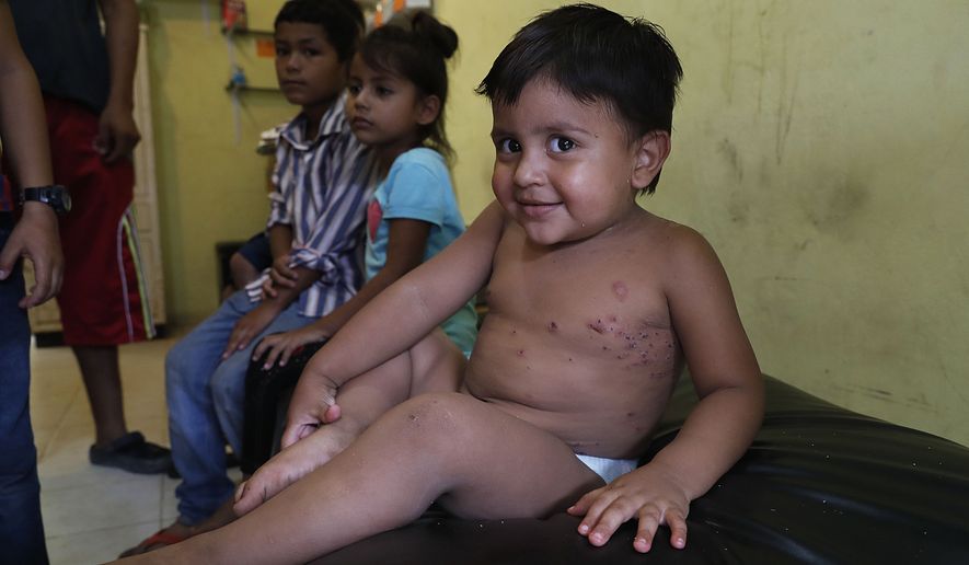 A migrant child smiles as he waits to be treated for an unknown infection on his body at the Jesus del Buen Pastor del Pobre y el Migrante shelter, in Tapachula, Mexico, Saturday, June 1, 2019. President Donald Trump threatened a 5% tariff on Mexican imports unless America&#39;s southern neighbor cracked down on Central American migrants trying to cross the U.S. border. (AP Photo/Marco Ugarte) ** FILE **