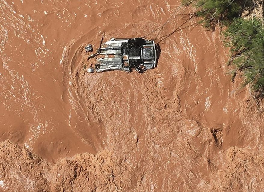 In this Friday, May 31, 2019 photo released by the Beaver Dam Littlefield Fire District shows an upside down vehicle in the Virgin River along Interstate 15 by bridge 7 near Littlefield, Ariz. Authorities say a Utah man sought in an alleged sex crime involving a juvenile is missing after his car went into a river in a northwestern Arizona gorge. Police in Hurricane, Utah, said in a statement that the man's car was spotted upside down after officers broke off a pursuit after the car entered Arizona. (Capt. Deborah Gates/Beaver Dam Littlefield Fire District Department via AP)