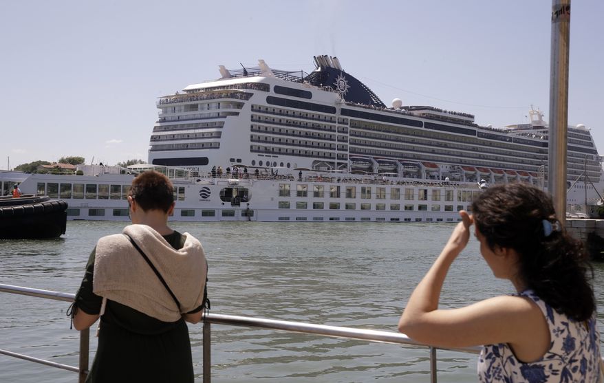 The tourist river boat that was struck by a towering cruise liner, foreground bottom, is dwarfed by the MSC Magnifica cruise liner passing by, in Venice, Italy, Sunday, June 2, 2019. The MSC Opera cruise ship has struck a dock and a tourist river boat on a busy canal in Venice. Italian media report that at least five people have been injured in the crash. (AP Photo/Luca Bruno)